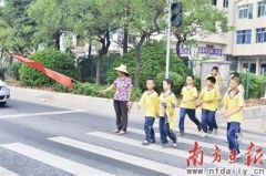 “马路天使”车流中护送学童 十九年风雨无阻